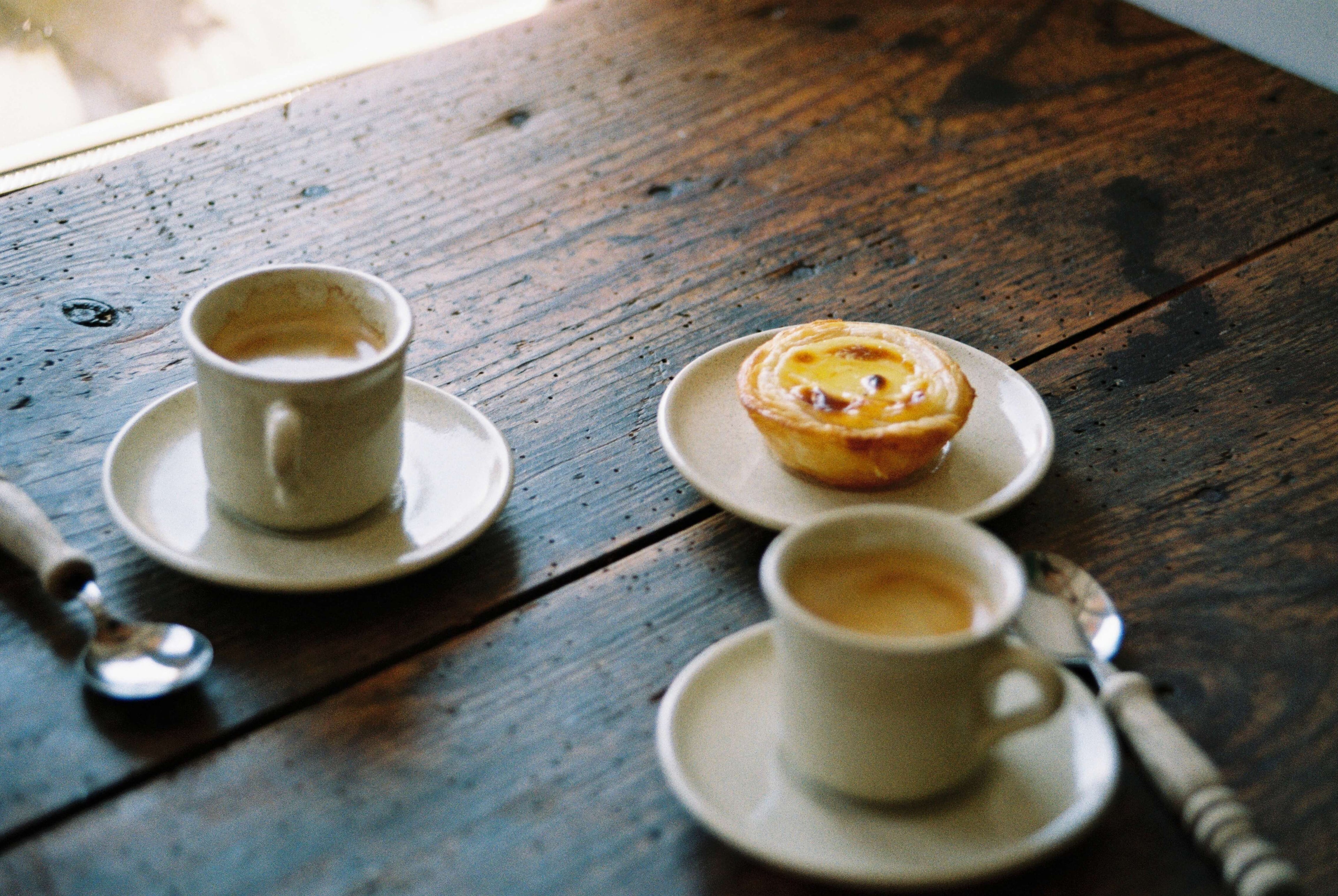 Analog Foto Espressotassen Steingut Geschirr Portugal auf dunklem Holztisch mit Pastel de Nata